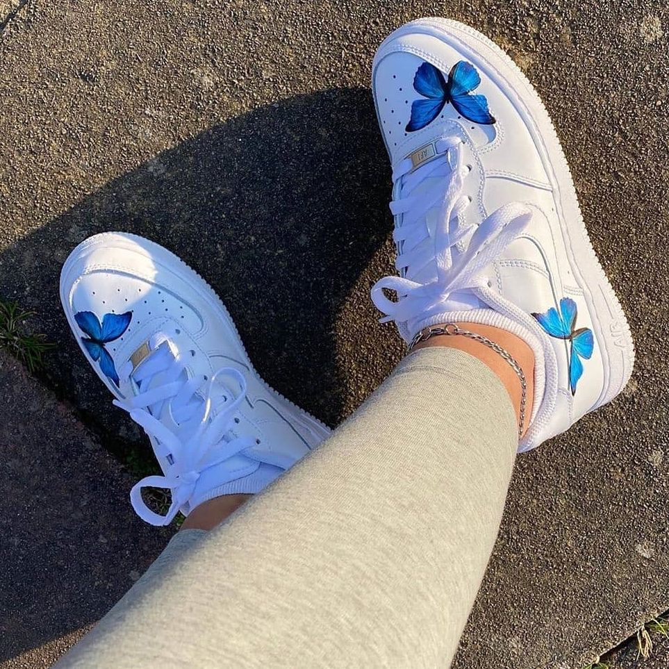 white nike shoes with blue butterflies